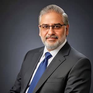 Portrait of Ali Khan, mature man in a suit with a blue tie