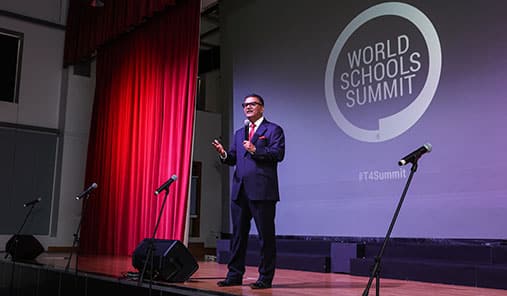 Speaker addressing the audience on stage at the World Schools Summit.