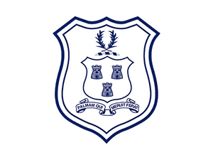 School crest with three tower symbols, laurel branch, and ribbon motto “Salvam Ole Libertate Peror”