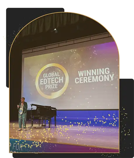 Global EdTech Prize awards ceremony presentation on stage with event branding and speaker Presenter standing on stage during the Global EdTech Prize winning ceremony with a large event screen in the background