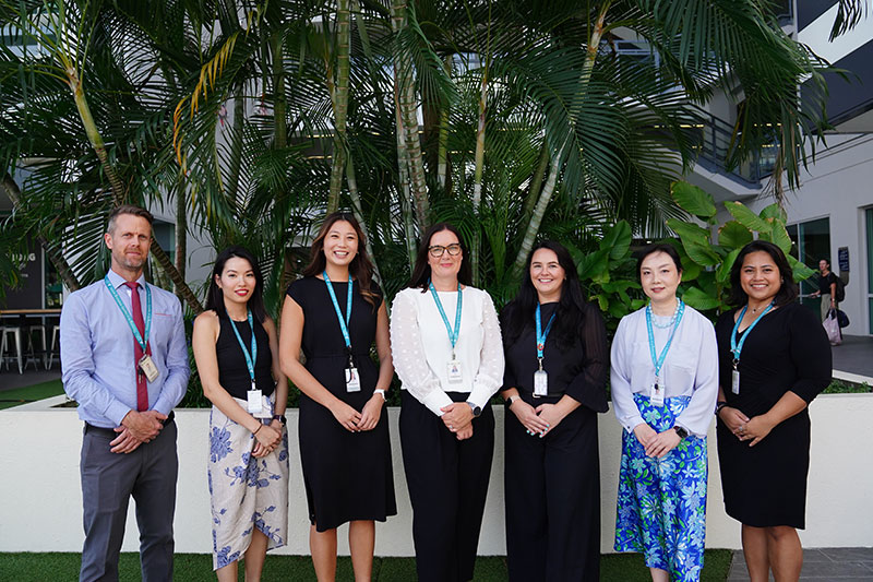 Members of the Australian International School faculty and leadership team standing together on campus.
