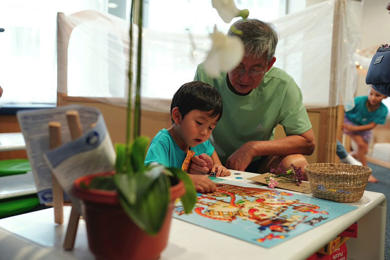 Young learner working alongside an educator during a hands-on early years learning activity that encourages curiosity and discovery.