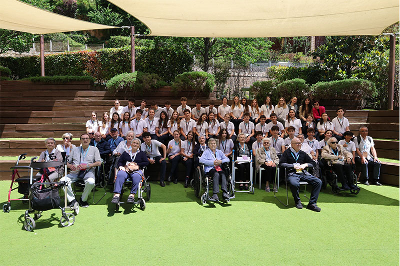 Students and senior community members gathered together in an outdoor learning space as part of an intergenerational education initiative.