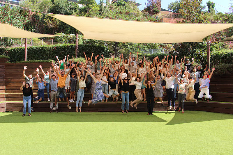 School staff and educators celebrating together in an outdoor learning space, reflecting a positive and collaborative school culture.