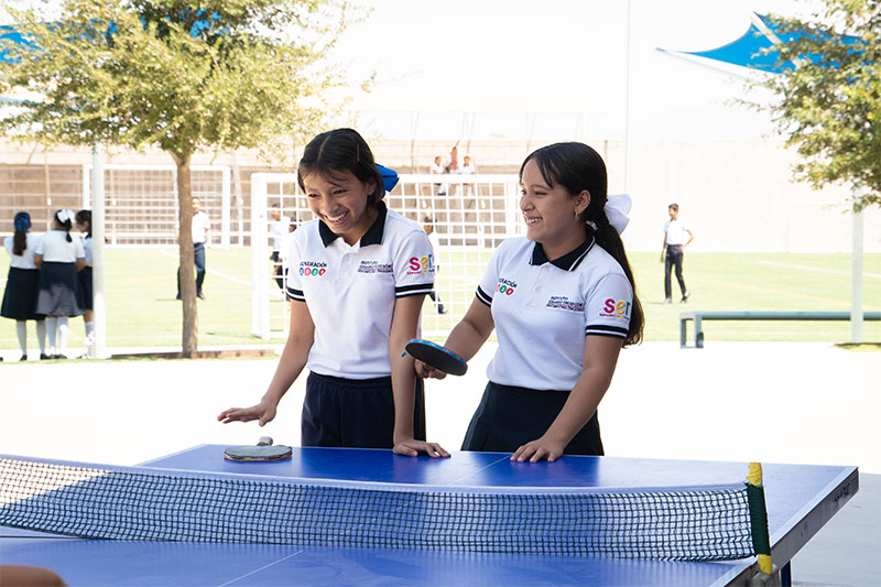 Students taking part in a coordinated outdoor activity on a school sports field, promoting teamwork, fitness, and student wellbeing.