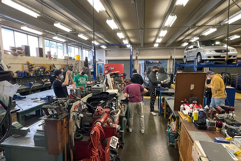Students developing automotive repair and maintenance skills in a vocational training workshop