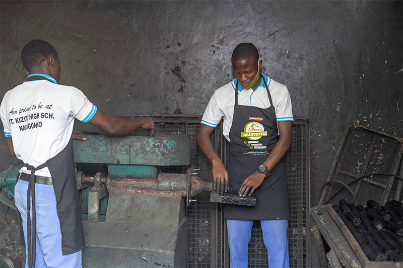 Students producing eco-friendly charcoal briquettes during a vocational skills training programme at St Kizito High School Nansana
