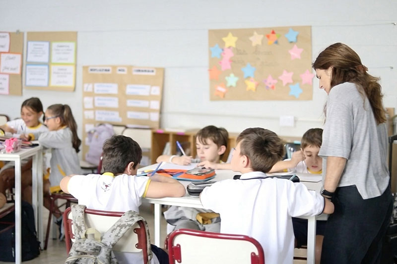 Teacher guiding students during a collaborative classroom lesson focused on active learning and academic development.