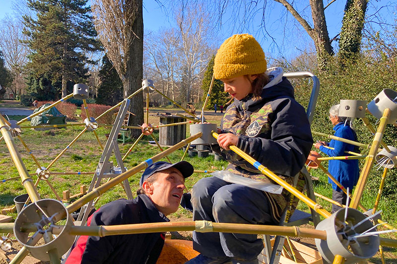 Student working alongside a mentor on an outdoor construction and design project that encourages creativity and problem-solving.