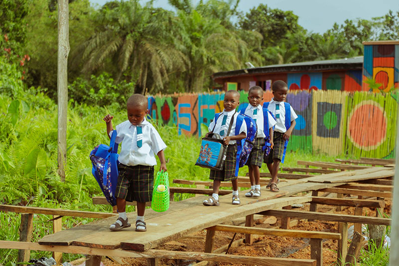 Young learners walking to school with backpacks at a Slum2School Africa education initiative in Africa