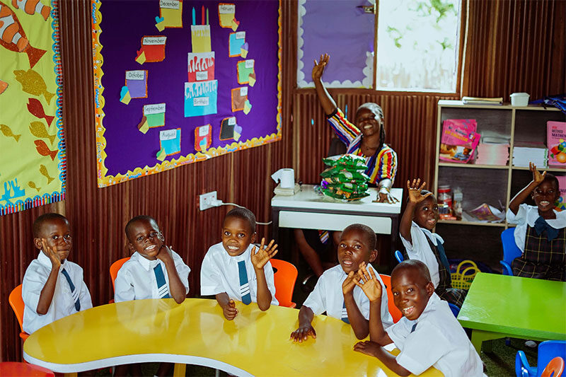 Children learning in a Slum2School Africa classroom with a teacher, promoting quality education and early childhood development