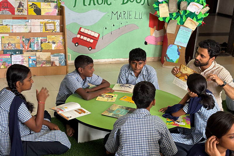 Teacher leading an interactive reading session with students during a literacy programme at a PCMC school