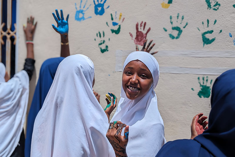 Abaarso School students participating in a creative community engagement activity with painted handprints