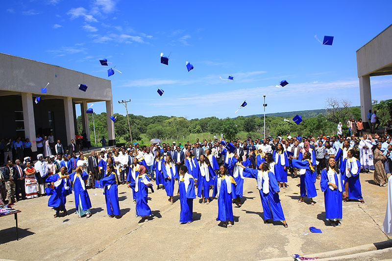 Graduates tossing their caps in celebration during a school graduation ceremony supported by the Pharo Foundation