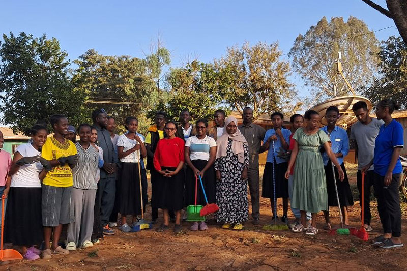Students and community members participating in a school clean-up and environmental stewardship initiative