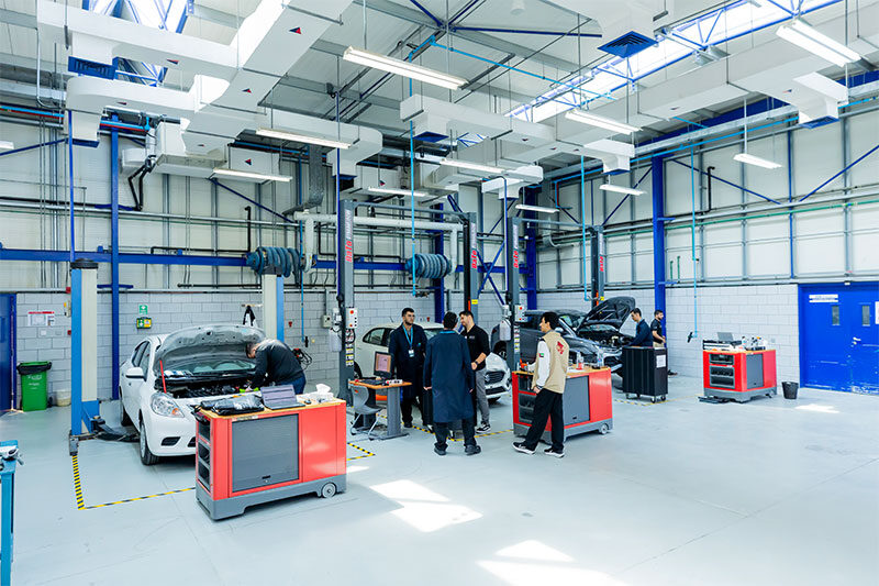 Students receiving hands-on automotive training in a modern vehicle maintenance workshop at Applied Technology Schools