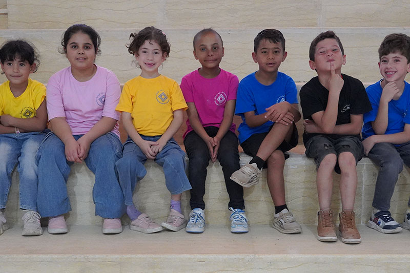 Young students seated together in colourful school uniforms at Ibn Rushd National Academy