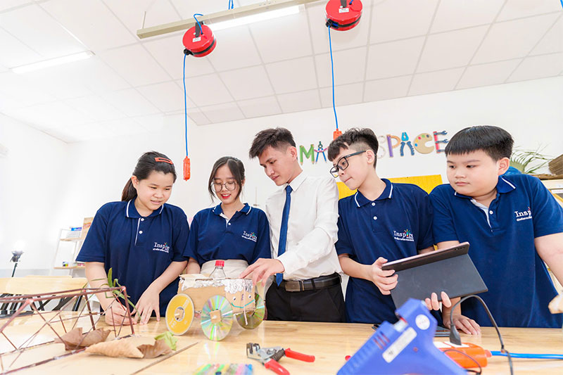Teacher mentoring students during hands-on STEM innovation and engineering activities at Inspire Schools