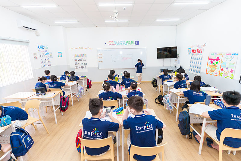 Students engaged in active classroom learning with teacher guidance at Inspire Schools