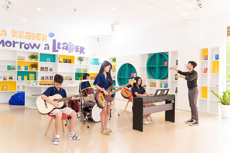 Students learning music and performing with guitars, drums and keyboard during an Inspire Schools arts program
