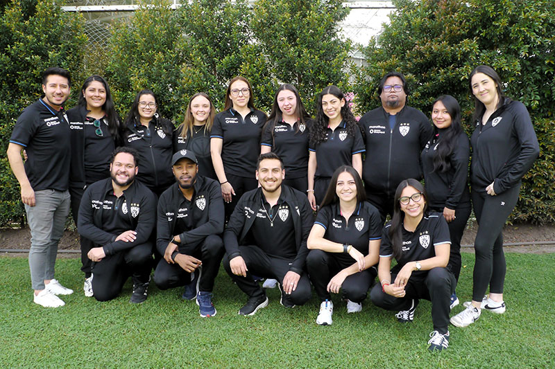 ReinventED IDV educators and staff team posing together outdoors during a school community event
