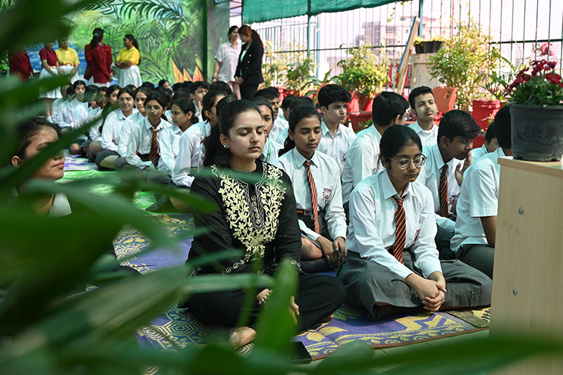 Students practicing meditation and mindfulness in a peaceful learning environment at Jaipuria School