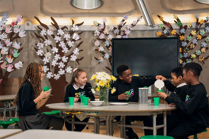 Students collaborating around a table during an interactive classroom learning activity at SSQ School