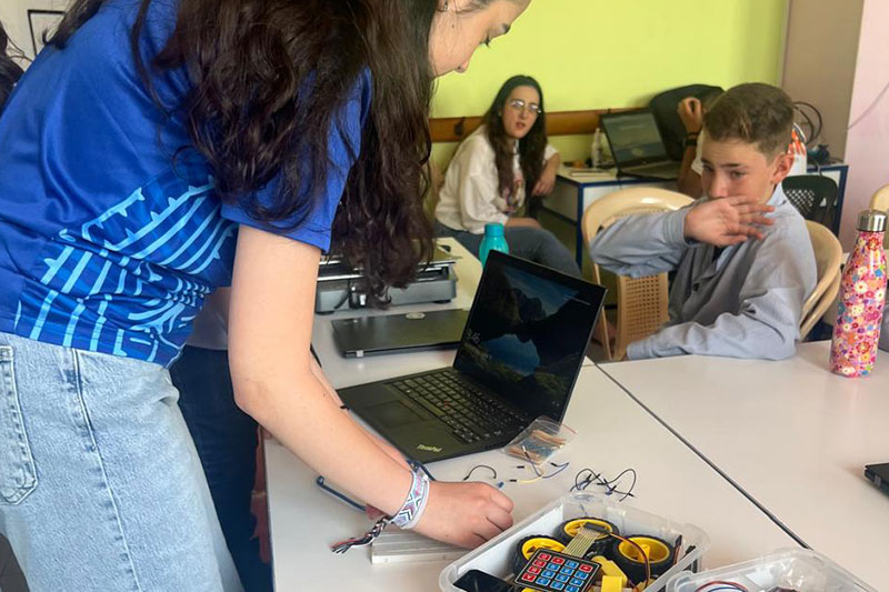 Students collaborating on a hands-on technology and robotics activity in a classroom environment